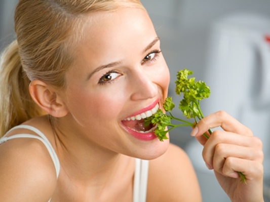 young happy smiling woman eating at kitchen